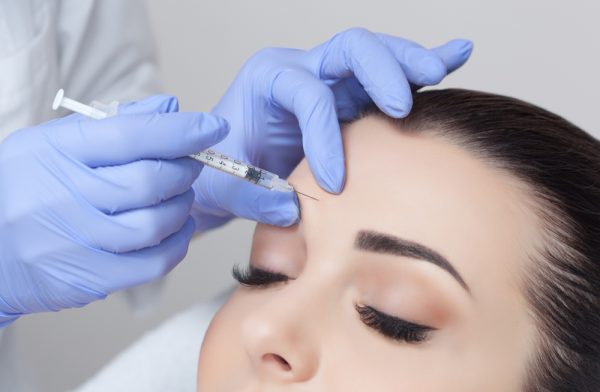 A woman getting an injection in her forehead.