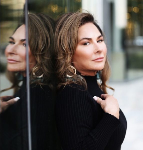 A woman is standing in front of a mirror